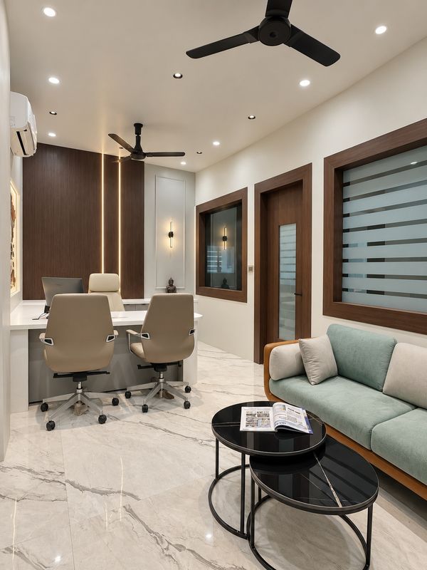 Office with the director's cabin beyond, glass panels framed in walnut and a sage sofa with nesting tables