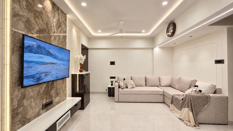 Living room with a marble-look TV wall, a floating white TV unit, a cove ceiling and a cream L-shaped sofa