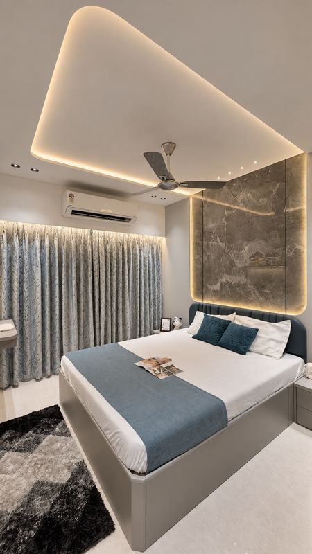 Bedroom with a curved, warmly lit ceiling over a backlit marble-look headboard wall and a grey bed