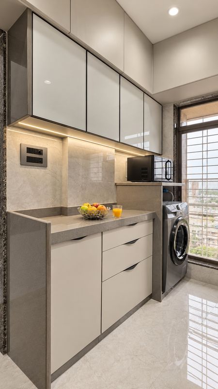 Kitchen with frosted glass uppers, under-cabinet lighting, a microwave shelf and a washing machine by the window
