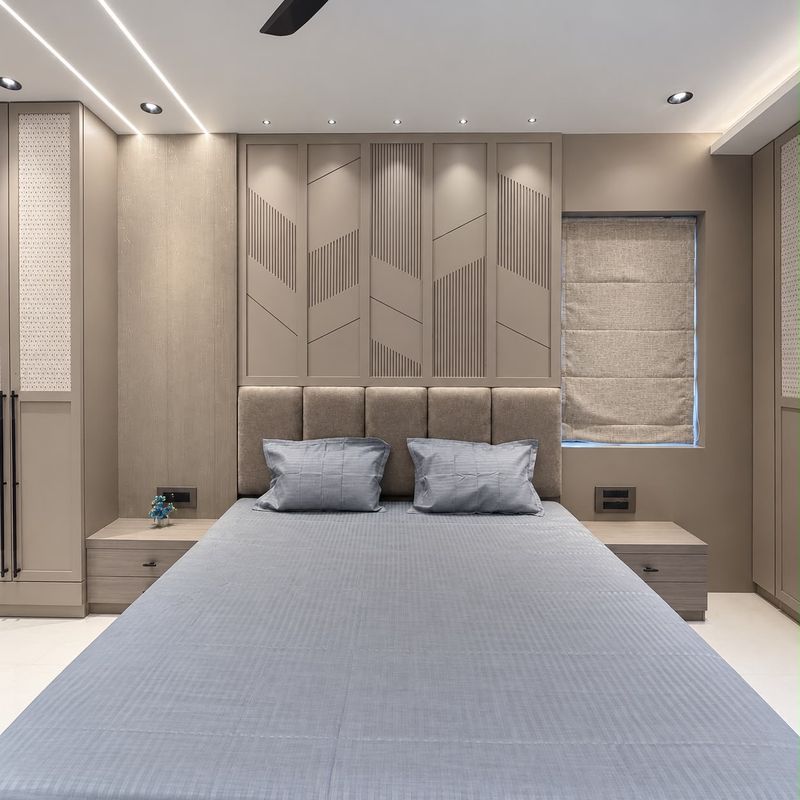 Bedroom with a panelled headboard wall in fluted and chevron patterns, cane-panel wardrobes and a roman blind