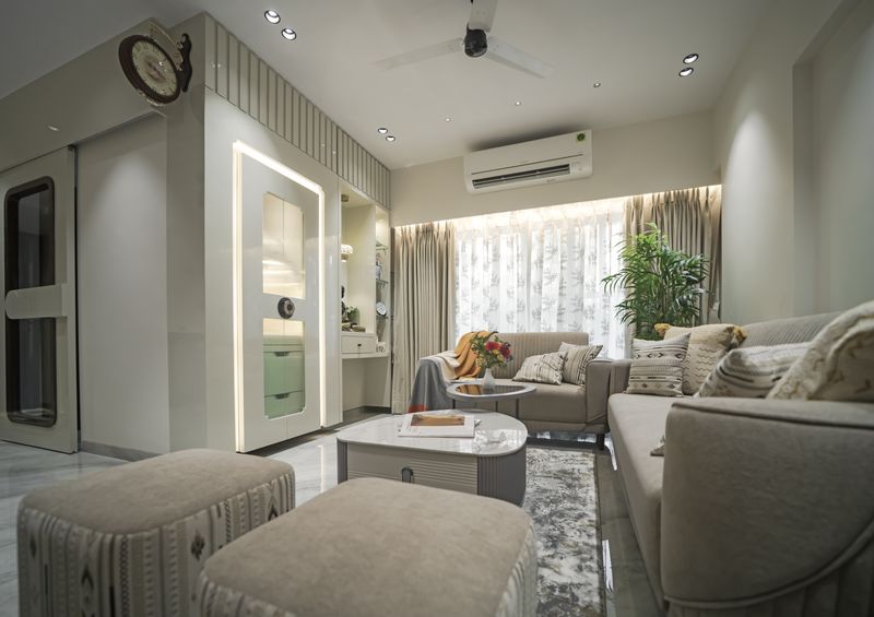 Living room with a grey sofa, round marble coffee table and a lit prayer unit