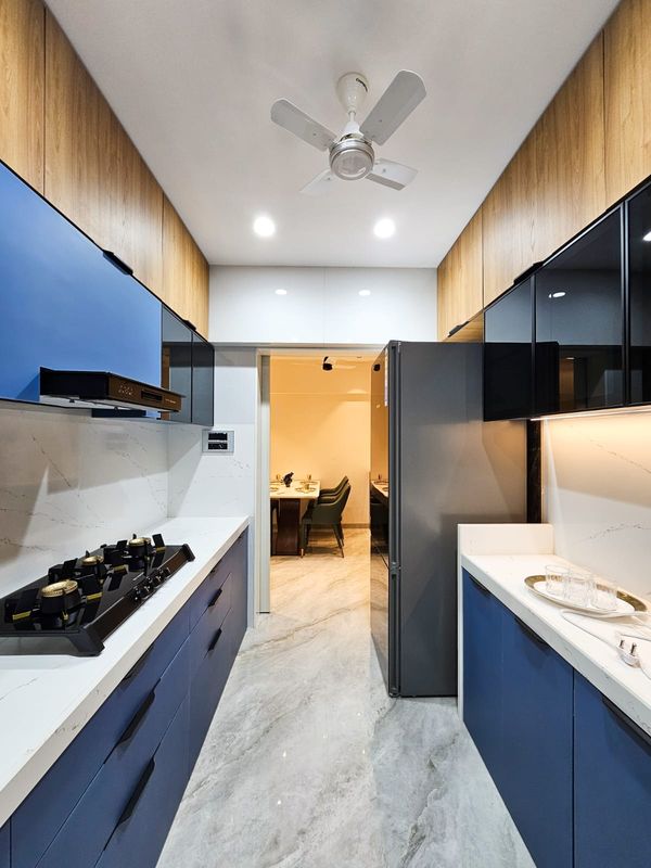 Galley kitchen with blue and wood finish cabinets and a white stone counter