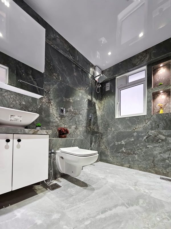 Second bathroom with stone-look wall tiles and a white vanity